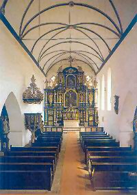 Deutlich erkennen wir hier die 1320 erfolgte Umwandlung der Decke in eine so genannte Holztonne. Im Hintergrund die um 1700 erbauten Altre.